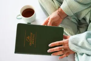 Hands holding a gratitude journal.