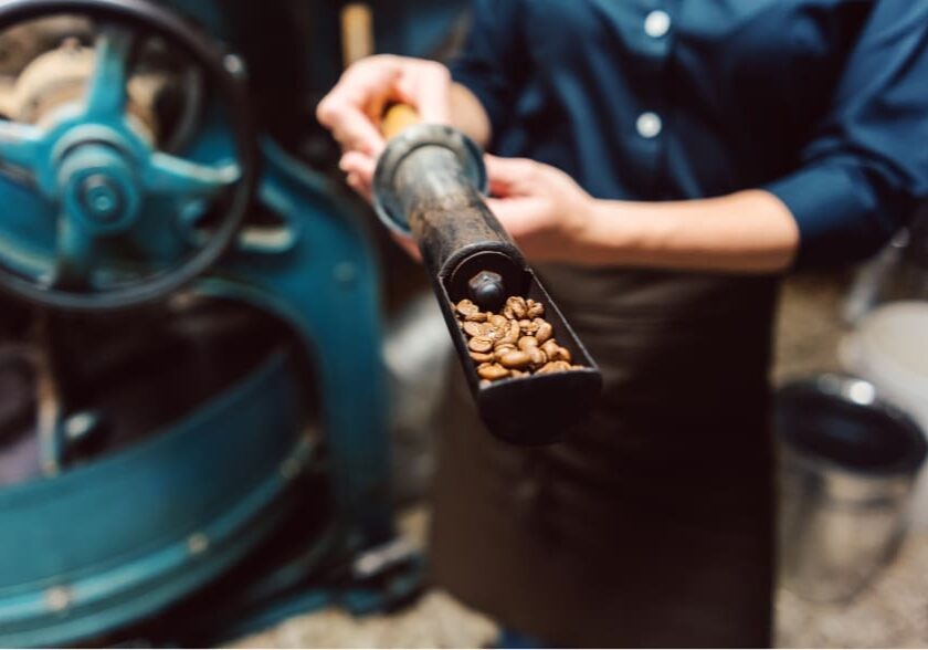 OurCoffeePage_Roasting A person holding an open tube of nuts.